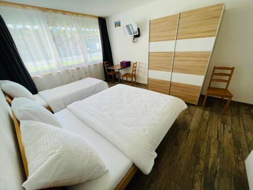 a hotel room with two beds and a desk at Swiss Chalet Holidays Ringgenberg in Ringgenberg