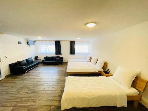 a hotel room with two beds and a couch at Swiss Chalet Holidays Ringgenberg in Ringgenberg