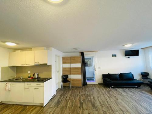 a living room with a couch and a kitchen at Swiss Chalet Holidays Ringgenberg in Ringgenberg