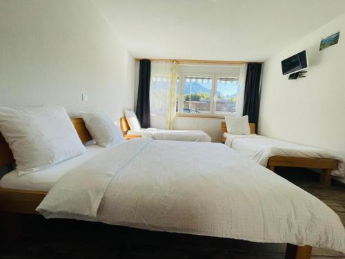 a bedroom with a large white bed and a window at Swiss Chalet Holidays Ringgenberg in Ringgenberg