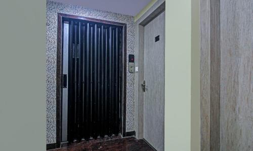 a black door in a hallway with a tile wall at Itsy Hotels Reotel Near Rabindra Sarobar in Kolkata