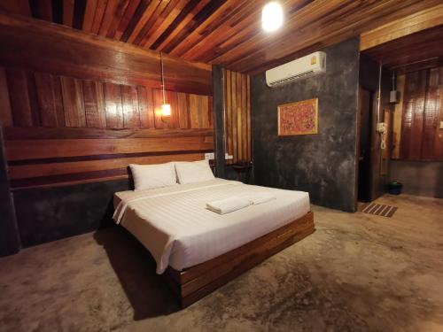 a bedroom with a large bed in a room with wooden walls at Chill Chill resort in Pran Buri