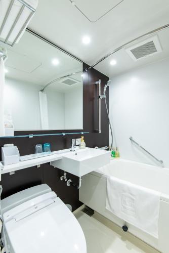 a bathroom with a sink and a toilet and a mirror at La'gent Hotel Shinjuku Kabukicho in Tokyo