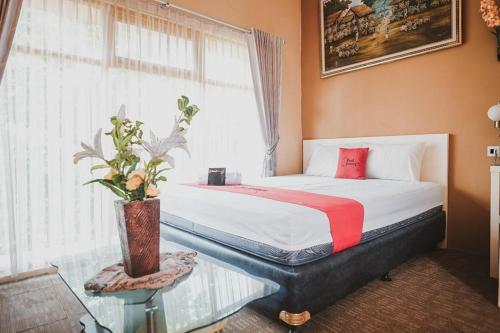 um quarto com uma cama com uma mesa de vidro e uma janela em Koolkost Syariah near Plaza Ambarukmo - Minimum Stay 30 Nights em Yogyakarta