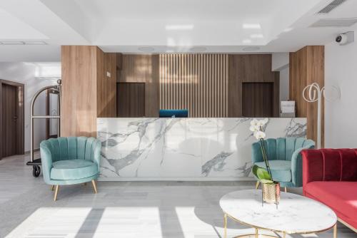 a lobby with two blue chairs and a table at Aparthotel Pietroasa in Buzău