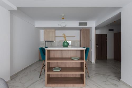 a kitchen with a table and some blue chairs at Aparthotel Pietroasa in Buzău