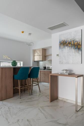 a kitchen with a table and chairs and a painting at Aparthotel Pietroasa in Buzău