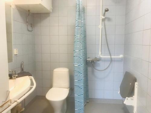 een badkamer met een douche, een toilet en een wastafel bij Muurame-City huoneet in Muurame