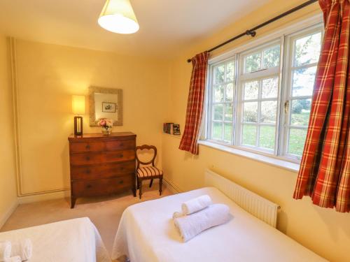 een slaapkamer met 2 bedden en een raam bij The Garden Flat at Holbecks House in Hadleigh