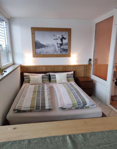 a bedroom with a bed with a cow picture on the wall at PenthouseApartment 250° in Sonthofen