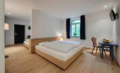 a bedroom with a bed and a desk and a table with a chair at Hotel Sachsenklemme in Fortezza