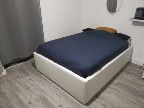uma cama branca com um cobertor azul em cima em Studio Le Nougat em Montélimar