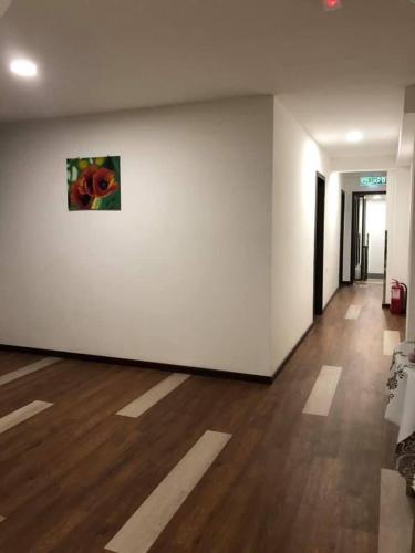 a room with a white wall and a painting on the wall at Kapit Hotel in Kuching
