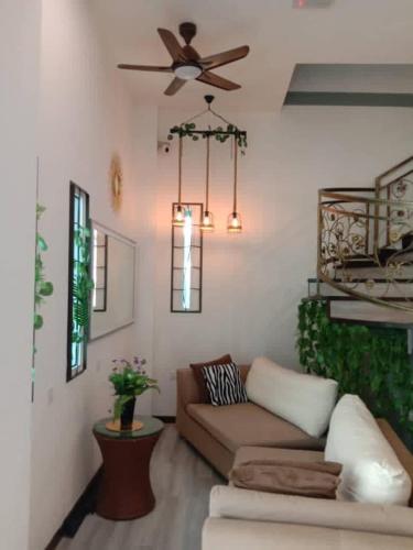 a living room with a couch and a ceiling fan at Kapit Hotel in Kuching