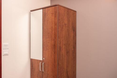 a wooden cabinet against a white wall at Dhimyaath Stay in Male City