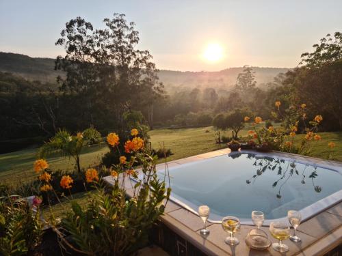a pool in a garden with a sunset in the background at Mackenzies Accommodation in East London