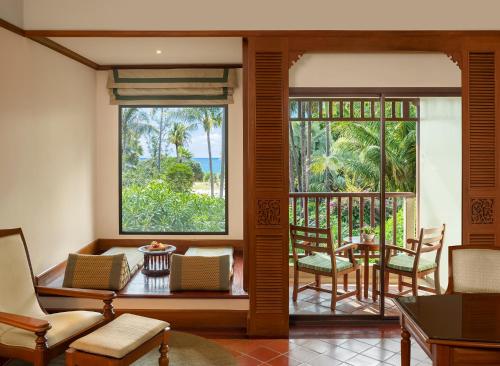 a living room with a balcony with a table and chairs at JW Marriott Phuket Resort and Spa in Mai Khao Beach
