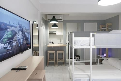 Dragonfly Apartments and Transient House في Bacoor: غرفة مع غرفة نوم مع سرير بطابقين وتلفزيون