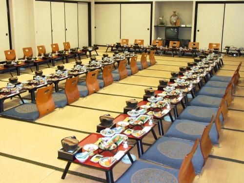 a large room filled with tables and chairs with food on them at Hotel Uguisu in Shizukuishi