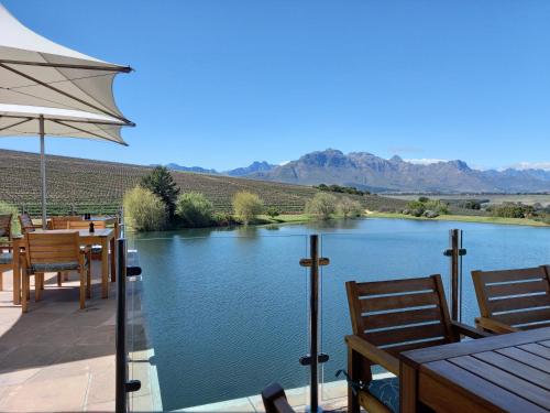 
a wooden bench sitting next to a lake at Asara Wine Estate & Hotel in Stellenbosch
