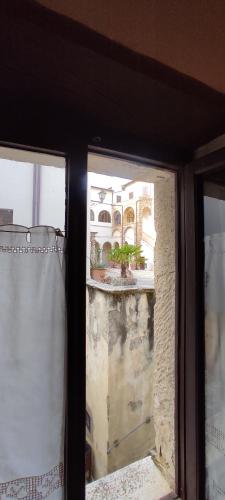 a window with a view of a house in the background at Dormire nel Castello in Pitigliano