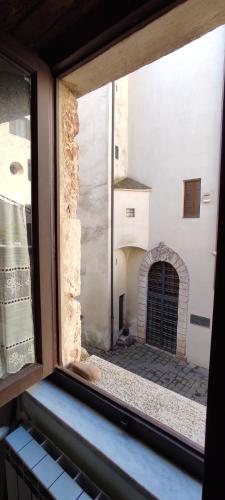 an open window with a view of a building at Dormire nel Castello in Pitigliano