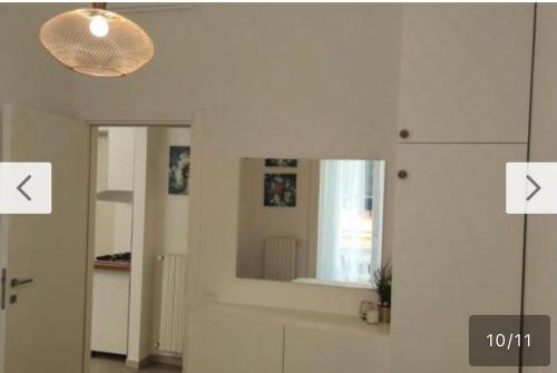 Cette chambre blanche est dotée d'un miroir et d'une lampe. dans l'établissement Casa Maria Al Porto, à Salerne