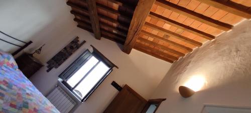 a bedroom with a bed and a window and wooden ceilings at Dormire nel Castello in Pitigliano