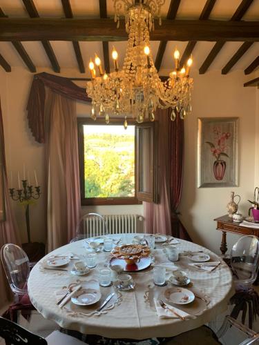 a dining room with a table with a chandelier at B&B L'Orologio in Signa