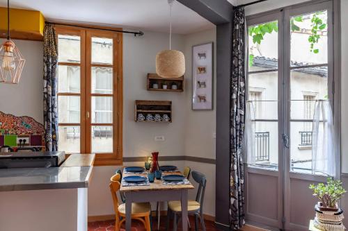 a kitchen with a table and chairs and a window at La Vie de Bohème Avignon in Avignon