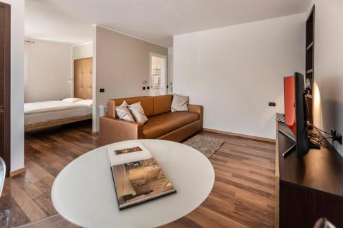 un soggiorno con un divano e un tavolo di APPARTAMENTI CAPRI MALCESINE a Malcesine