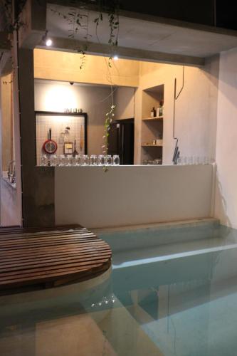a room with a swimming pool with a table and a bench at Trava House in Yogyakarta