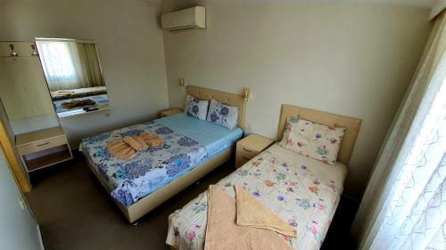 two beds in a small room with a mirror at Ressa Apart in Marmaris