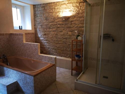 Das Bad ist mit einer Badewanne und einer Dusche ausgestattet. in der Unterkunft Maison familiale de l Abbaye in Clairvaux