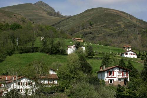 a group of houses on a hill with mountains at Hôtel Juantorena in Saint-Étienne-de-Baïgorry