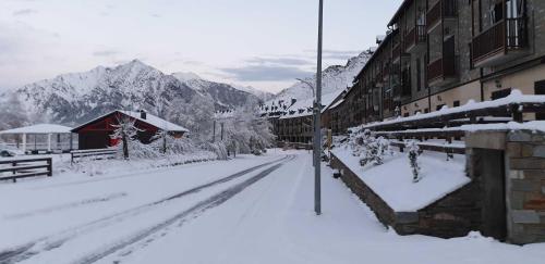 a street covered in snow with mountains in the background at Hotel Taüll in Pla de l'Ermita