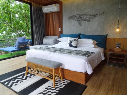 a bedroom with a large bed and a balcony at The Cabin Beach Resort in Haad Rin