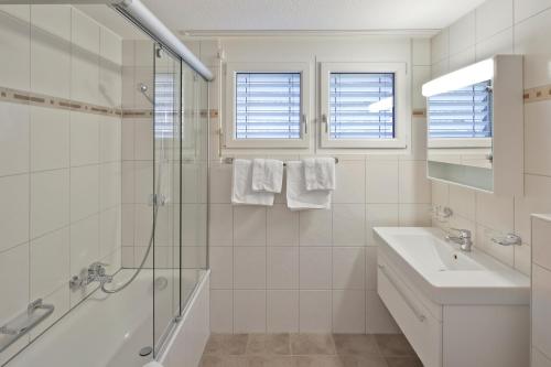 ツェルマットにあるCasa Collinettaの白いバスルーム(シンク、シャワー付)
