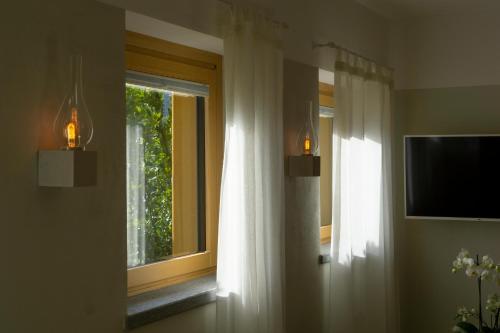 a window in a room with a television and a window with curtains at Agriturismo Terra del Sole in Albosaggia