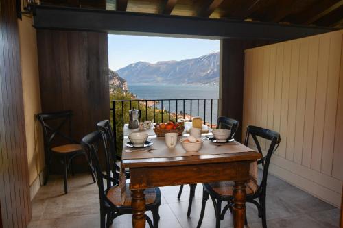 a table with chairs and a view of the ocean at Cascina Varini in Gargnano