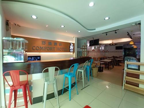 a restaurant with colorful chairs and a counter at Comfort Hotel in Kota Kinabalu