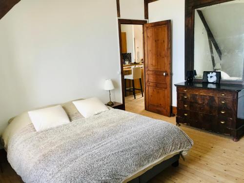 une chambre avec un lit, une commode et un miroir dans l'établissement La Madelon Front de mer, à Villers-sur-Mer