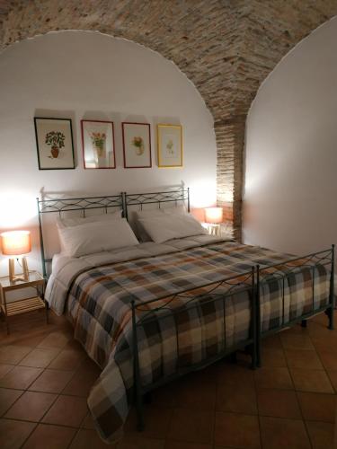 um quarto com uma cama num quarto com uma parede de tijolos em Bed and Breakfast In Piazza Orazio em Venosa