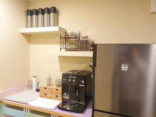 a kitchen with a refrigerator and a coffee maker on a counter at 小窩旅店-羅東夜巿店 in Luodong