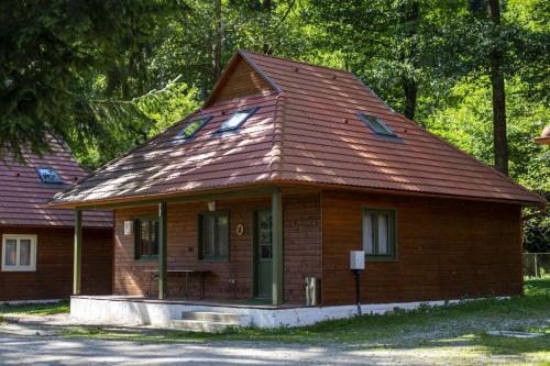 a small wooden house with a shingled roof at Tusnad Camping in Băile Tuşnad
