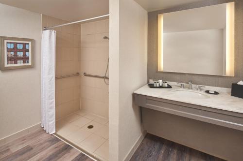 een badkamer met een wastafel en een douche bij Sheraton Detroit Novi in Novi