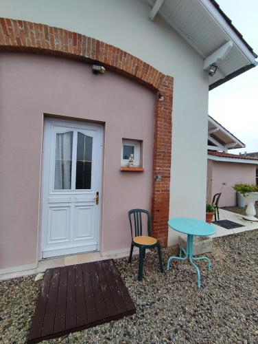 a table and a chair in front of a house at chambre d'hôtes in Verdun-sur-Garonne