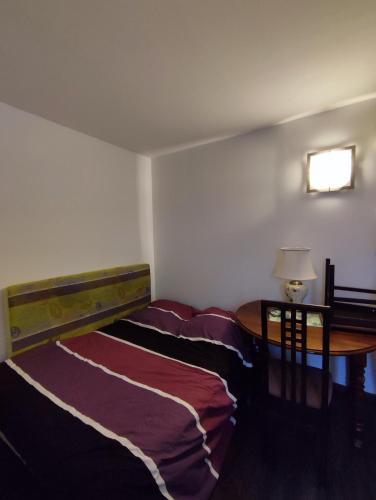 a bedroom with a bed and a table with a lamp at chambre d'hôtes in Verdun-sur-Garonne