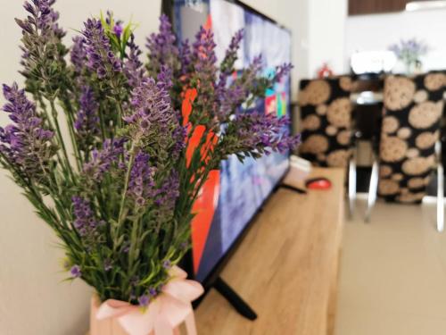 a vase of purple flowers sitting on a table at Landmark Lovely Coast View King Suite#500mbpsWifi#Netflix in Tanjong Tokong
