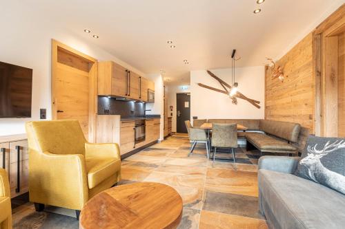 a living room with a couch and a table at Tauernlodges Uttendorf by ALPS RESORTS in Uttendorf